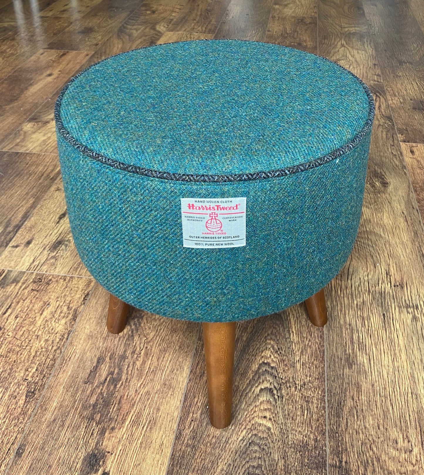 Green Harris Tweed Footstool with Charcoal Piping and Dark Varnished Wooden Legs.