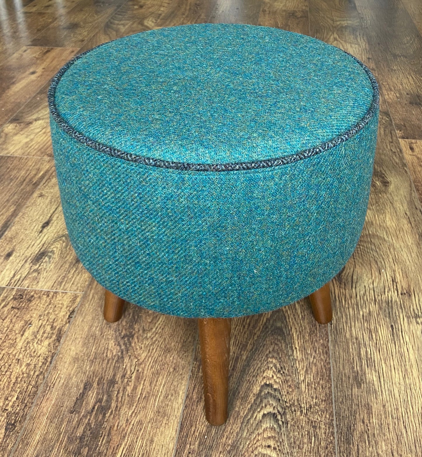 Green Harris Tweed Footstool with Charcoal Piping and Dark Varnished Wooden Legs.