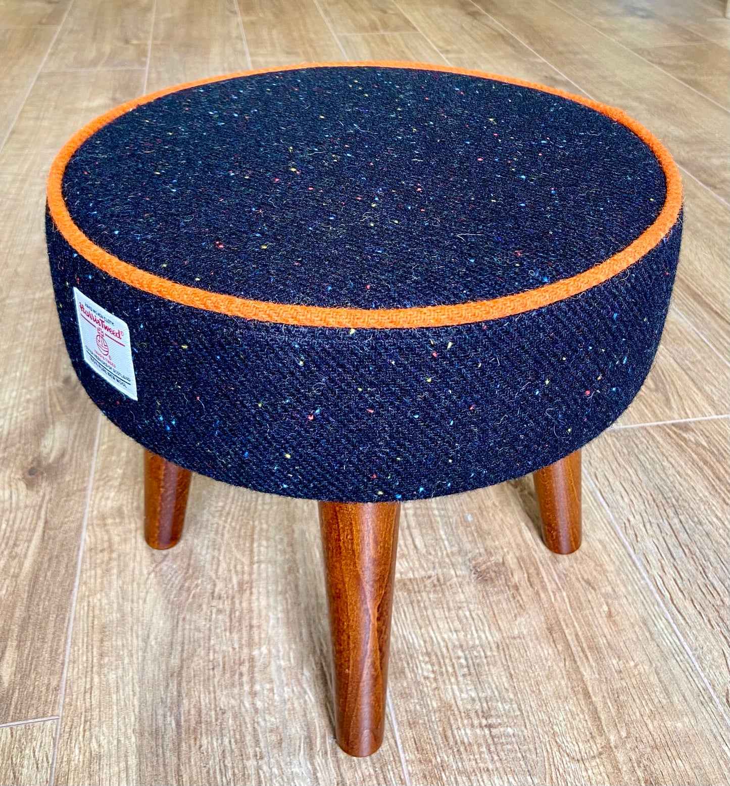 Black Speckled Harris Tweed Footstool with Orange Piping and Dark Varnished Wooden Legs